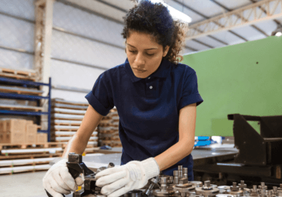 Woman working in a factory with gloves on