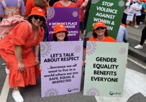 WHISE staff and partners holding signs for gender equality at Walk Against Family Violence March