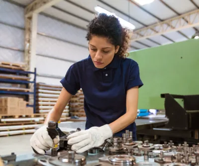 Woman working in a factory with gloves on