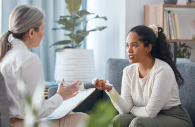 A young woman sitting and talking to a health professional during a consultation